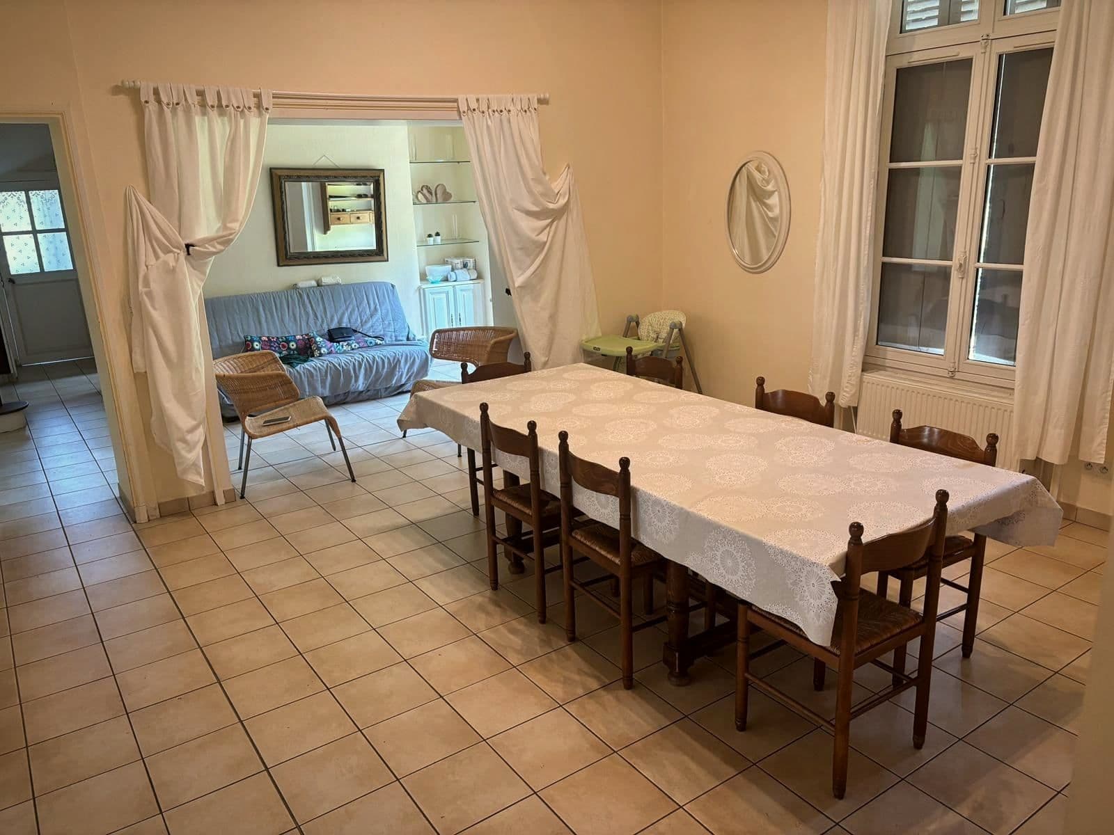 La grande salle à manger commune, avec une longue table dressée d’une nappe blanche.