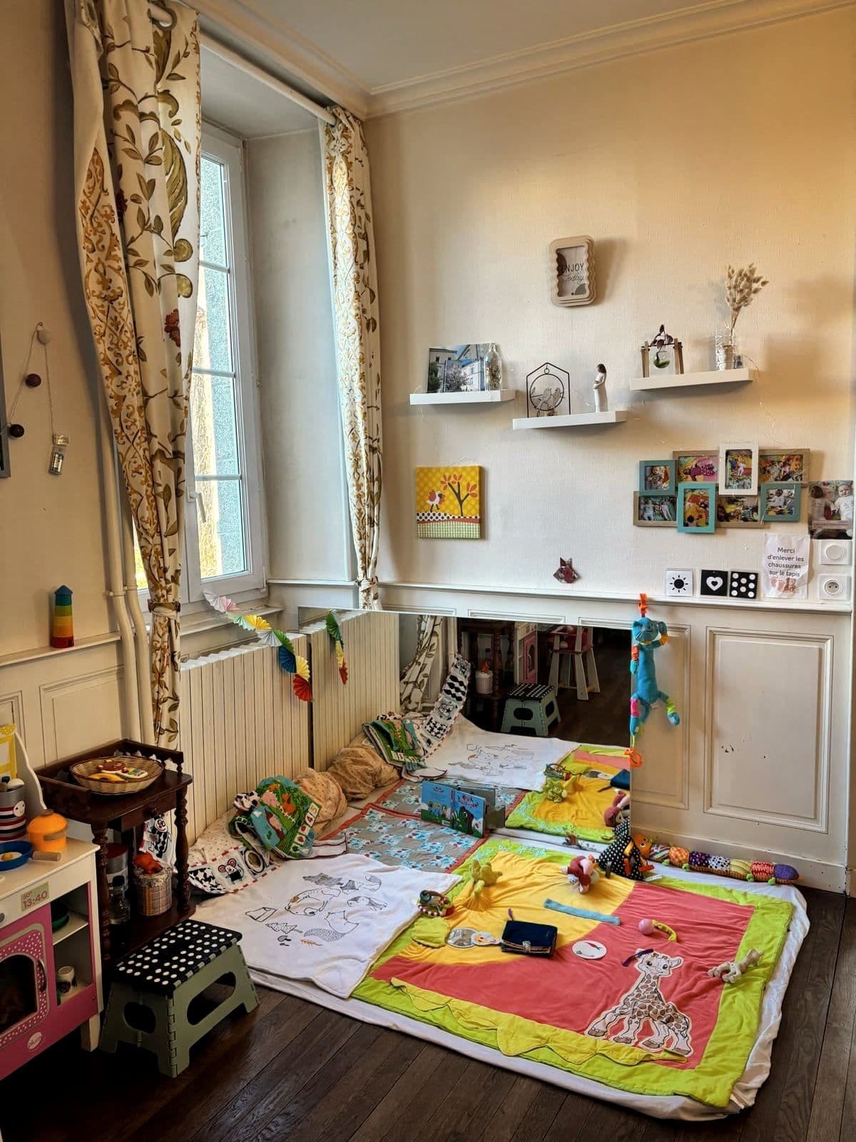 Le coin bébé d’une des maisons : un lit à barreaux, une table à langer et des jouets rangés.