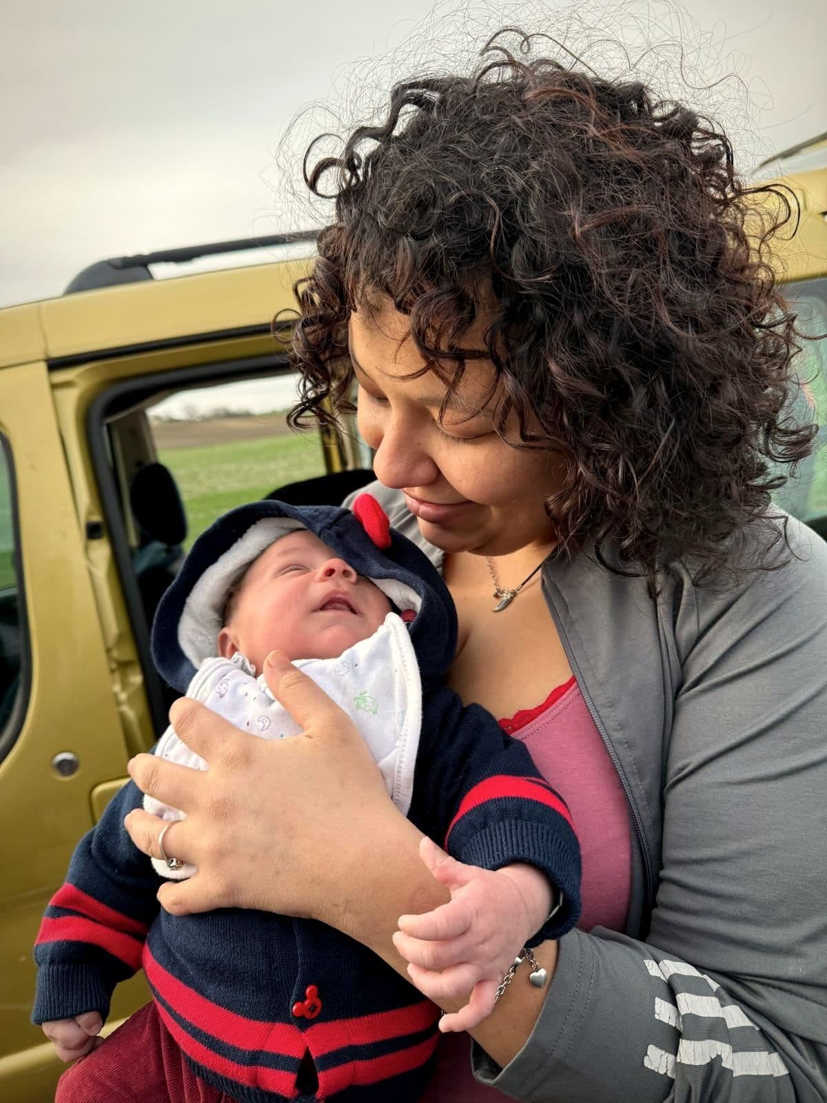 Yasmine, accueillie à Ligueil, tient son bébé dans ses bras et le regarde.